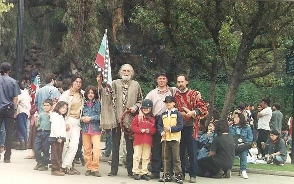 Gastón con poncho y una bandera de Chile en medio de un grupo